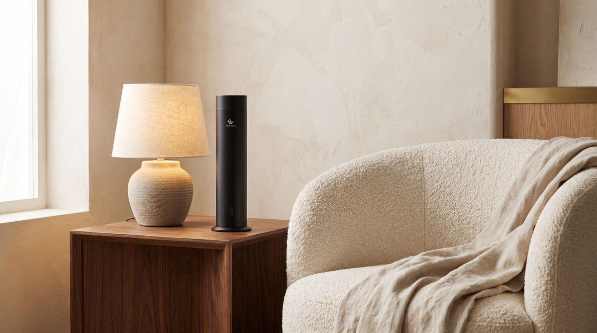 Pure One Diffusor in Matte Black neben einer Keramiklampe und einem Bouclé-Sessel in einem Interieur mit vielen Strukturen